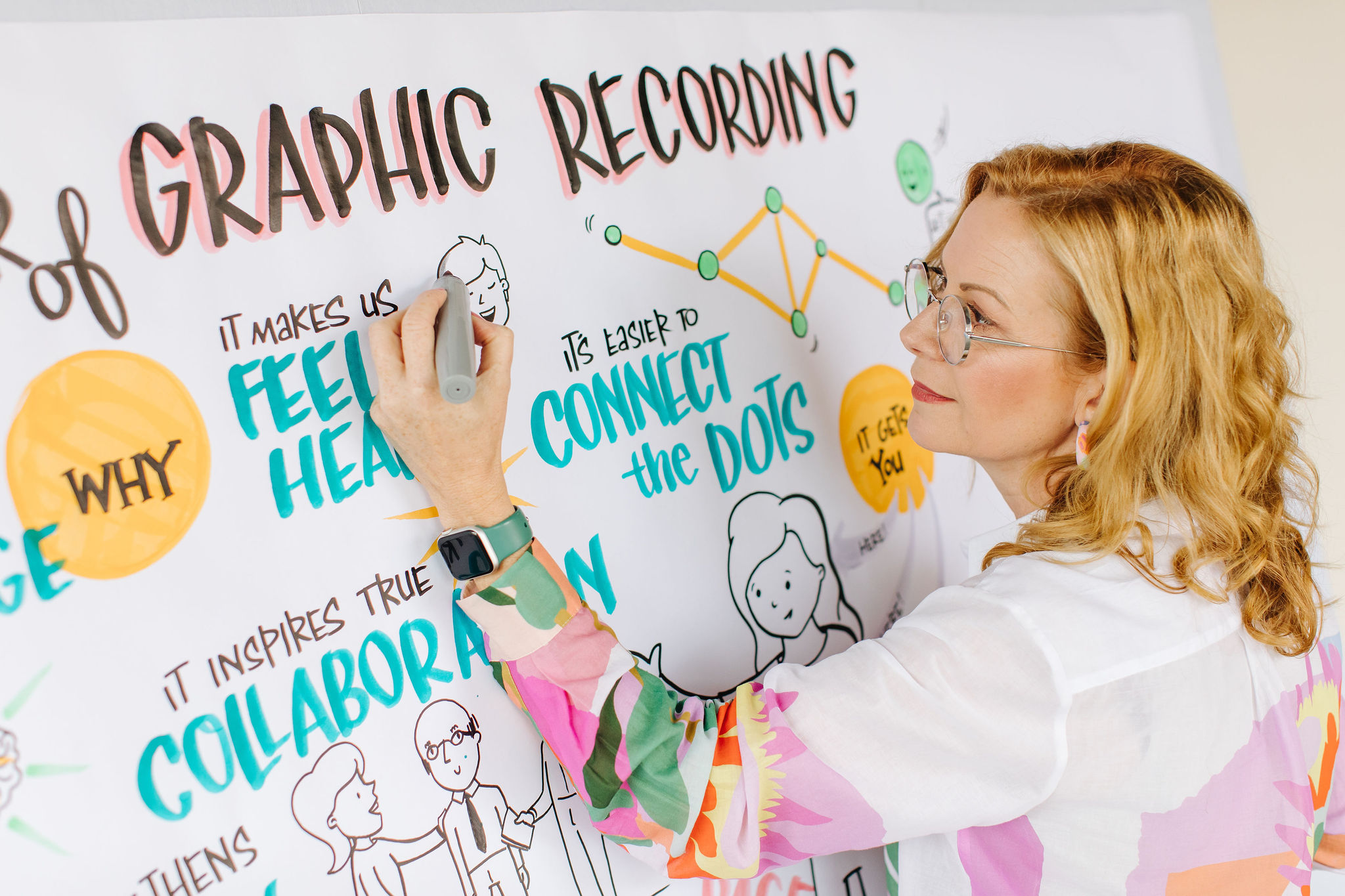 Debbie Wood Graphic Recorder working with markers on a wall